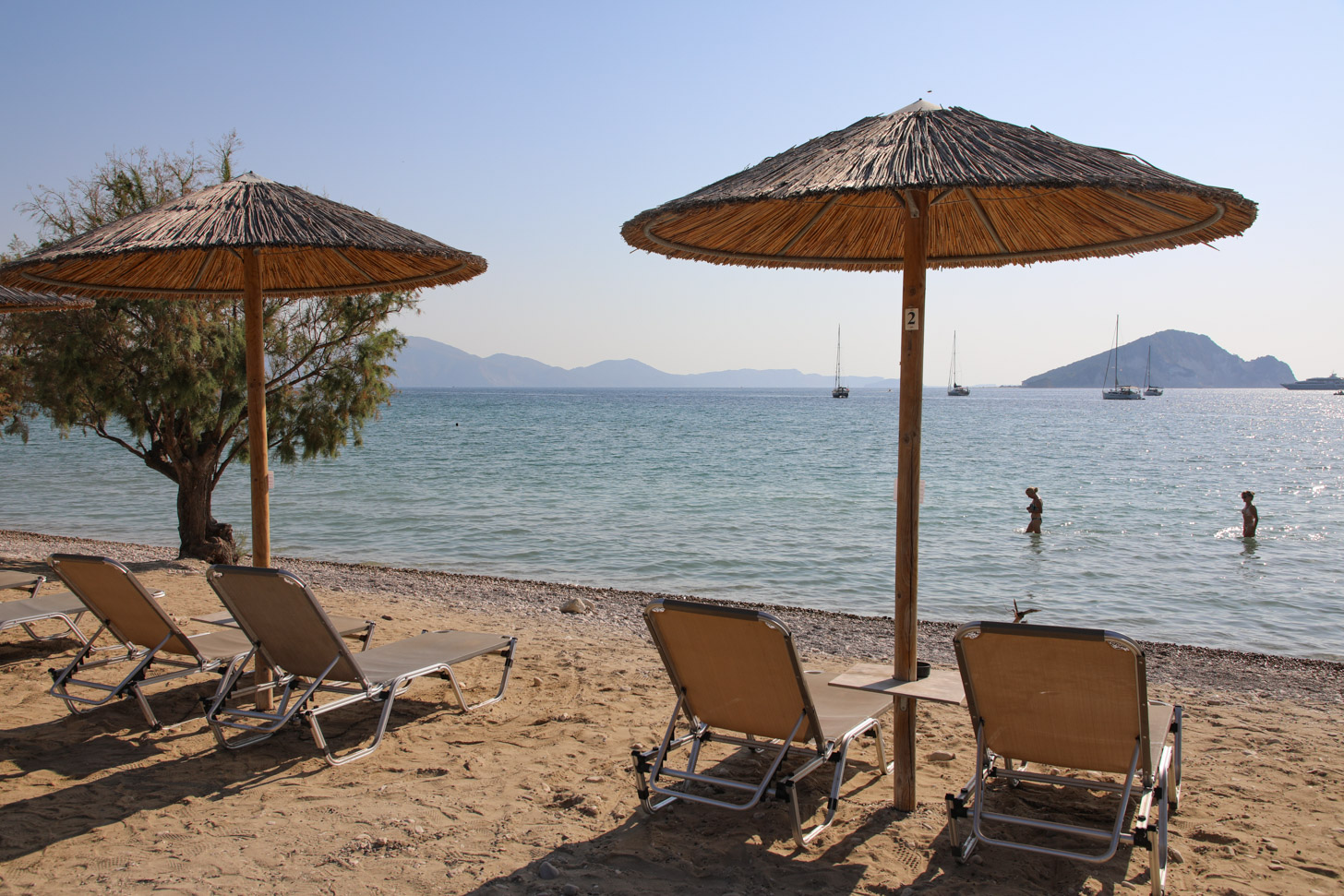 Keri Beach with clear turquoise waters and boat excursions